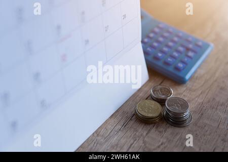 Nahaufnahme des Rechners, Kalenders und Münzen. Fälligkeitsdatum, Buchhaltung und Ratenzahlungskonzept. Stockfoto