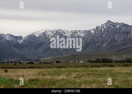 Die schneebedeckten Gipfel der fernen Berge des Breede Valley an einem kühlen Tag in Worcester, Südafrika Stockfoto