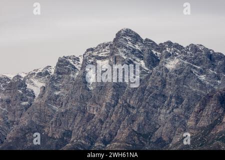 Die schneebedeckten Gipfel der fernen Berge des Breede Valley an einem kühlen Tag in Worcester, Südafrika Stockfoto