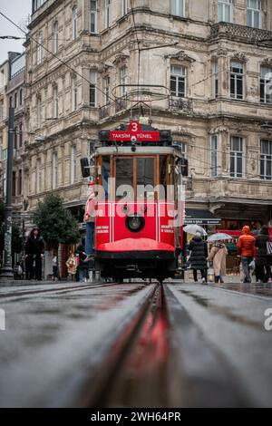 Regnerisches Rendezvous: Die Rote Straßenbahn von Istanbuls nassen Straßen Stockfoto