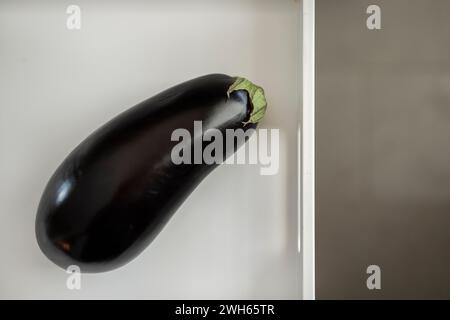 Ein Blick von oben auf eine isolierte Aubergine auf einem weißen Tablett Stockfoto