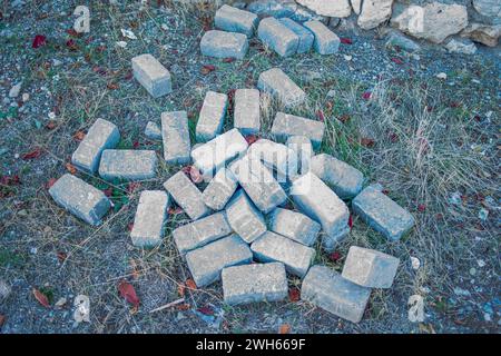 Betonsteinpfähle auf dem Boden bilden einen zerklüfteten, ungeordneten Stapel, der die Überreste von Bauwerken und der städtischen Industrielandschaft verkörpert Stockfoto