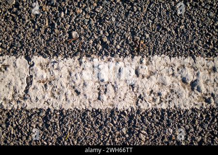 Ein künstlerischer Hintergrund mit Asphalt und Straßenmarkierungen, die urbanes Design und abstrakte Muster auf den Straßen der Stadt verbinden Stockfoto