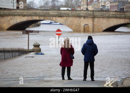 Die Menschen in York stehen und starren auf das Wasser neben den überfluteten Ufern des Flusses Ouse, während Sturm Jocelyn trifft und starke Winde und Regen weitere f Stockfoto