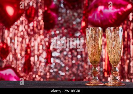 Festlicher Hintergrund zum valentinstag mit Kopierraum. Festliches rotes Bokeh aus Lametta, Ballons und romantischer Dekoration, unfokussiert Stockfoto