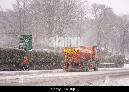 In Buxton, Peak District, läuft eine Person an einem streckenden LKW vorbei. In Teilen Englands und Wales werden bis zu 25 cm Schnee prognostiziert, da das Met Office Wetterwarnungen ausgab und vor Reisestörungen warnte. Bilddatum: Donnerstag, 8. Februar 2024. Stockfoto