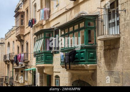 Die Wäsche hängt zum Trocknen vor den Fenstern eines Gebäudes in Valletta, Malta Stockfoto