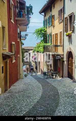 Touristen gehen zu Fuß zum Yachthafen in Malcesine, Gardasee, Italien Stockfoto