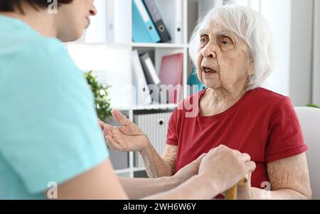 Alte Frau Beschwert Sich Beim Arzt Über Gesundheitsprobleme In Der Arztpraxis Stockfoto