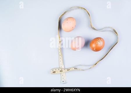 Hühnereier und Maßband, gesundes Ernährungskonzept auf weißem Hintergrund Stockfoto