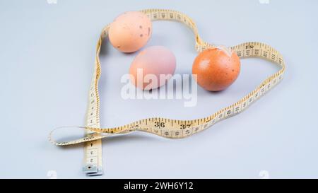 Hühnereier und Maßband, gesundes Ernährungskonzept auf weißem Hintergrund Stockfoto