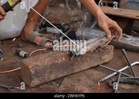 Schweißer arbeiten am Schweißen von Metall. Männer, die in der Schweißwerkstatt arbeiten Stockfoto