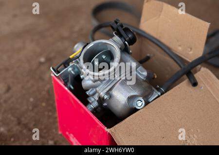 Motorradvergaser in einer Verpackungsbox. Stockfoto