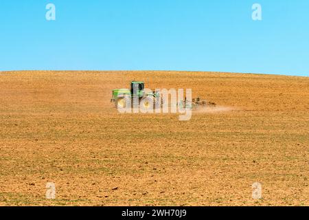 Landwirtschaftslandschaft eines John Deere Traktors bei Frühjahrspflügen in Overberg, Westkap, Südafrika Stockfoto