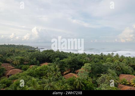 Das Dach der Villen mit Fliesen in Dschungelbäumen neben dem Strand mit Blick auf die Drohne Stockfoto