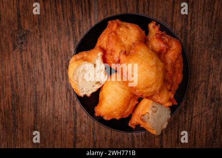 Hefepfannkuchen auf einem schwarzen Teller. Dunkler Hintergrund, Holzbrett. Polnisches Gebäck. Ende des Karnevals, Donuts. Fetter Donnerstag. Stockfoto