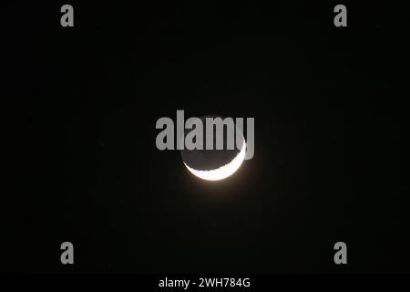 Ein wachsender Halbmond und Sterne, die nachts mit einem Teleobjektiv über der Dominikanischen Republik fotografiert wurden. Stockfoto