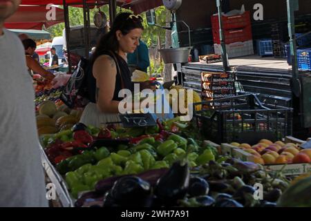 Frau, die Obst und Gemüse auf dem Markt Vouliagmeni Athen Attika, Griechenland, wählt Stockfoto