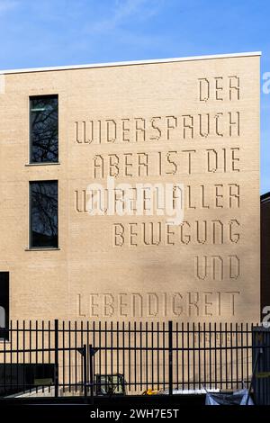 Neuausbau des Hansa-Gymnasiums am Gereonswall, Zitat von Georg Wilhelm Friedrich Hegel an der Fassade, Übersetzung: Widerspruch ist die Wurzel eines Stockfoto