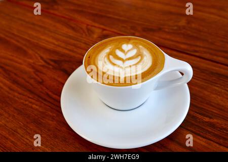 Tasse Kaffee in einer weißen Tasse und Untertasse auf einem Holztisch Stockfoto