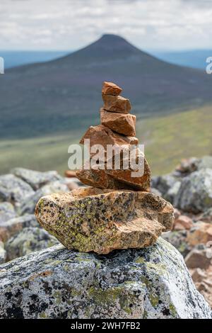 Auf dem Gipfel des Nipfjället bilden gestapelte Steine im Sommer einen Stein oder eine Pyramide, die von Touristen erbaut wurde, im Hintergrund der Berg Städjan. Dalarna Schweden Stockfoto