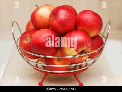 Schöne reife Äpfel liegen auf einem Teller auf einem Küchentisch Stockfoto