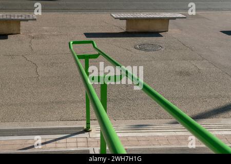 Handlauf am Eingang eines öffentlichen Gebäudes, um Personen beim Treppensteigen zu unterstützen. Elemente aus grünem Stahl, unverzichtbar und widerstandsfähig Stockfoto