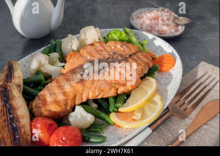 Gegrilltes Lachssteak mit Gemüse - Blumenkohl und Brokkoli, Tomaten und Schalotten. Konzept für gesunde Ernährung. Nahaufnahme Stockfoto