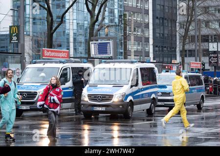 Karneval in Köln, Zülpicher Platz, Zülpicher Straße, 08.02.2024 Polizisten, Polizeiautos stehen neben der Haltestelle Barbarossaplatz, auf dem Vordergrund sieht man Teilnehmer, unscharfer Karneval in Köln, Zülpicher Platz, Zülpicher Straße, 08.02.2024 Köln Zülpicher Platz, Zülpicher Straße, 08 2024 Polizeibeamte Polizeiautos stehen neben der Haltestelle Barbarossaplatz, im Vordergrund sehen Sie Teilnehmer, verschwommener Karneval in Köln, Zülpicher Platz, Zülpicher Straße, 08 02 2024 Köln Zülpicher Platz, Zü Stockfoto