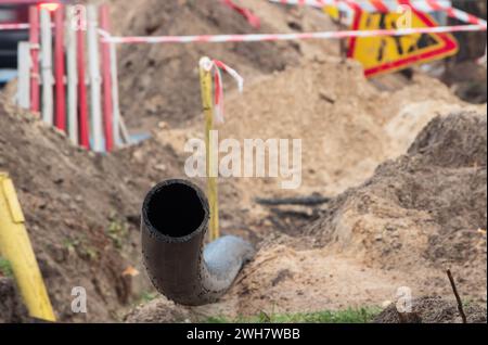 Schwarzes Kunststoffrohr für unterirdische Wasserversorgung. PVC-Rohr. Reparatur des Kanalsystems. Nahaufnahme. Stockfoto