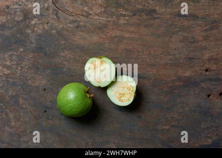 Guave auf hölzernem Hintergrund, oval geformte gewöhnliche tropische und nährstoffreiche Früchte, die reich an Vitamin C, Ballaststoffen und Antioxidantien sind Stockfoto