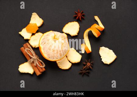 Komposition mit frischer Orange, Schale und Gewürzen auf dunklem Hintergrund Stockfoto