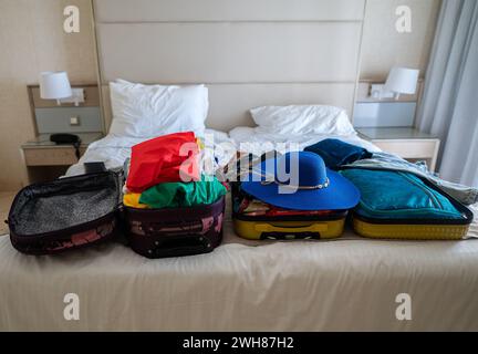 Koffer mit Kleidung auf dem Bett. Vorbereitung auf den Urlaub. Stockfoto