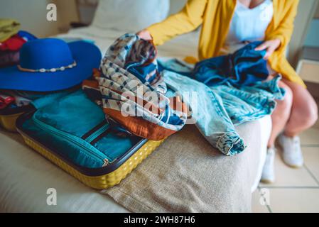 Die Frau packt ihre Kleider in einen Koffer. Vorbereitung auf den Urlaub. Stockfoto