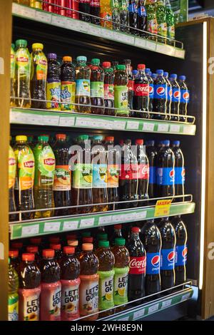 Plastikflaschen mit Limonade und kaltem Tee verschiedener Marken. Coca Cola, Pepsi, Lipton, Fuze. Verkaufsregal, große Auswahl, Getränke-Editorial, beliebte Carbo Stockfoto