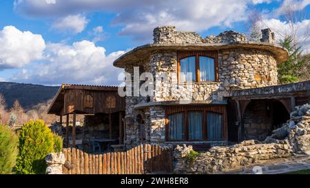 Steinhaus in Kroatien mit Bergblick, eingezäuntem Hof und üppigem Laub Stockfoto