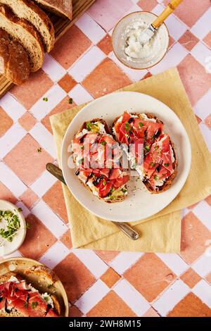 Ricotta- und Parmaschinken-Toast mit Balsamico-Drizzle und Kresse auf gekacheltem Hintergrund Stockfoto