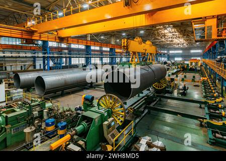 Fertigtransport von Rohren mit einem Deckenkran in einer Rohrfabrik. Stockfoto