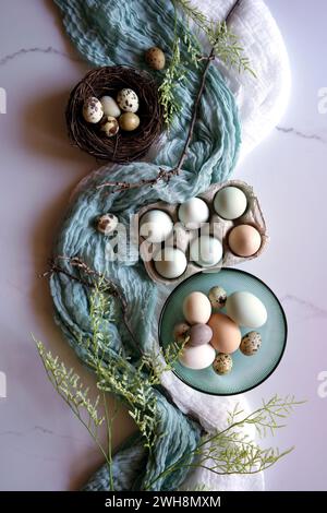 Araucana Hühnereier in freier Reichweite, einschließlich blauer und grüner Farben, mit japanischen Jumbo-Wachteleiern. Creative Concept Flatlay. Stockfoto