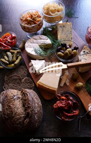 Gesunde probiotische Käseplatte serviert mit Kimchi, Sauerteigbrot mit dunkler Färbung und fermentiertem Gemüse. Nahaufnahme. Stockfoto