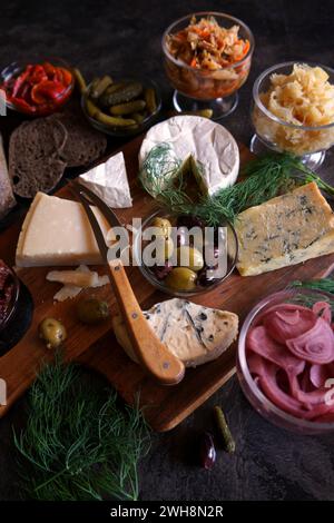 Gesunde probiotische Käseplatte serviert mit Kimchi, Sauerteigbrot mit dunkler Färbung und fermentiertem Gemüse. Nahaufnahme. Stockfoto