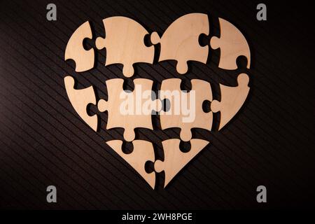 Form der Herzen aus Karton Rätsel gemacht. Valentines Tag Hintergrund mit Herzen von Jigsaw puzzle Teile auf weißem Hintergrund. Stockfoto