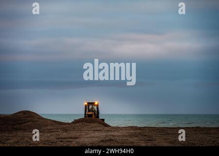 HASTINGS, ENGLAND - 3. FEBRUAR 2024: Wiederherstellung des Kieselstrands an der Küste von Hasting an einem Winterabend. Stockfoto