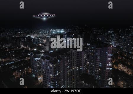 Ein außerirdisches Raumschiff fliegt nachts über die Stadt. UFO, außerirdische Besucher Stockfoto