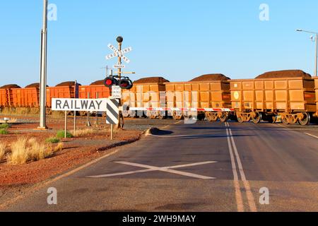 Eisenerz-Eisenbahnwaggons und Bahnübergänge, Pilbara, Western Australia Stockfoto