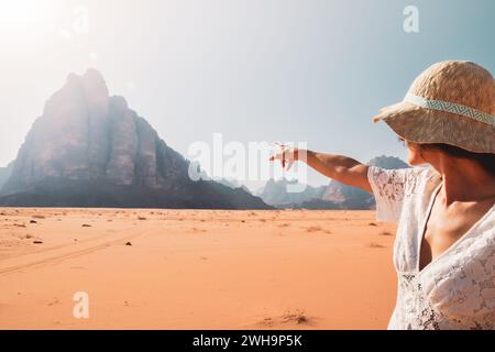 Zurück Ansicht weibliche Touristen beobachten mit dem Finger auf sieben Säulen des Weisheitsdenkmals im Wadi Rum-Wüstenreservat im Nahen Osten. Entdecken Stockfoto