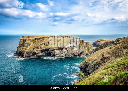 Die Insel, der Standort eines Teils von Tintagel Castle, ist durch die neuen und alten Fußgängerbrücken, von Glebe Cliff und dem SW Coast Path aus gesehen. Stockfoto