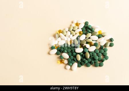 Mockup ausgewählte Stapel von bunten Pillen, Grün weiß Gelb, Beige Tabletten, Kapseln, medizinische Ergänzung auf Beige Hintergrund. Kopierbereich Für Text Stockfoto