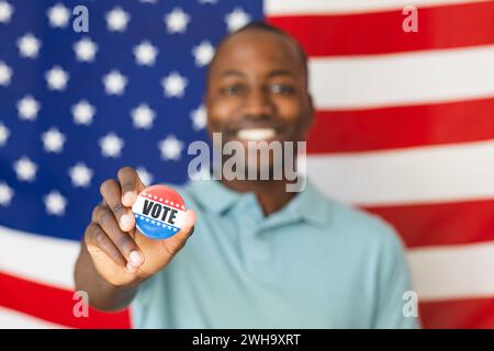 Der junge Afroamerikaner zeigt einen "Abstimmungsknopf" Stockfoto