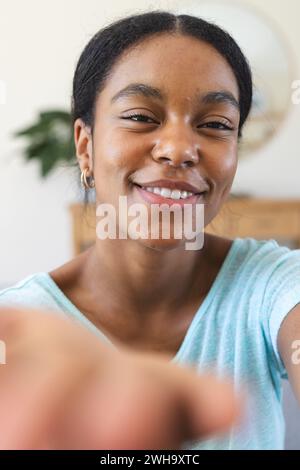 Eine junge Frau, die bei einem Videoanruf in die Kamera lächelt Stockfoto